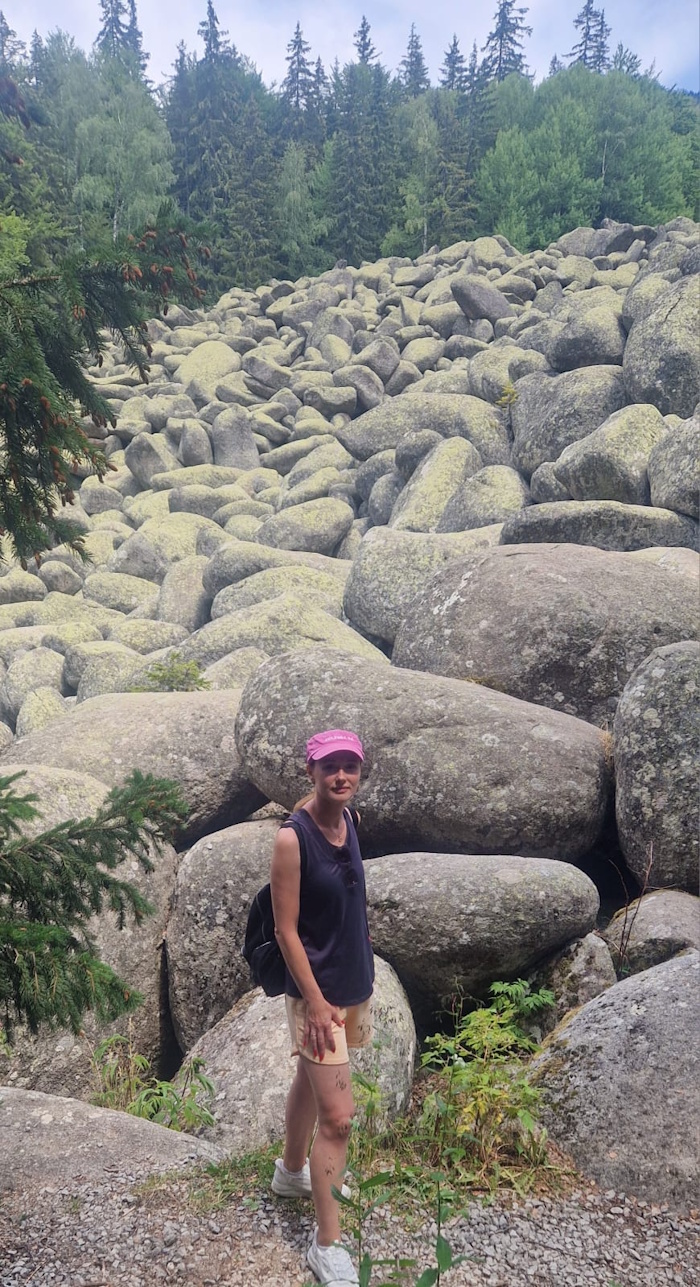 Aneliya Majdanac beim Wandern vor einem beeindruckenden Feld großer Gesteinsbrocken
